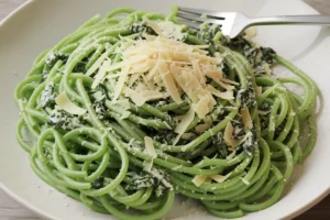 Green spaghetti, or Espagueti Verde, is a colorful and flavorful dish that has found its way into many homes. Known for its creamy green sauce, this green spaghetti recipe uses poblano peppers, cilantro, and cream cheese as its primary ingredients. The combination of these creates a rich, smoky, and tangy sauce that perfectly complements spaghetti. Simple yet versatile, this green spaghetti recipe can fit into many dietary preferences.

This article covers everything you need to know about green spaghetti: its origins, essential ingredients, recipe variations, and tips for making it at home. Whether you’re a first-time cook or an experienced chef, you’ll discover how to make and customize this delicious green spaghetti recipe.

Introduction to Green Spaghetti
Green spaghetti, sometimes referred to as Mexican green spaghetti or Espagueti Verde, stands out because of its vibrant green sauce. The dish's bold color comes from the roasted poblano peppers that form the base of the sauce. These mild chili peppers bring a subtle smokiness and a slight heat to the dish, blending beautifully with creamy elements like cream cheese and sour cream.

Though it’s often compared to Italian pesto pasta due to its color, this green spaghetti recipe has its own distinct flavors. Instead of relying on basil and pine nuts, the green hue and flavor in this dish come from poblanos, cilantro, and dairy. The combination gives the dish a richness that balances out the mild heat of the peppers.

What makes this green spaghetti recipe particularly appealing is its versatility. Green spaghetti works well as either a main dish or a side, making it a perfect choice for family dinners or special gatherings. Additionally, the recipe can be adjusted for dietary restrictions, such as creating vegan green spaghetti or gluten-free green spaghetti.

For a more traditional take on the recipe, Taste of Home offers a delicious green spaghetti recipe that’s easy to follow.

Origins of Green Spaghetti
The roots of green spaghetti lie in Mexican cuisine and Tex-Mex cuisine, where it is known as Espagueti Verde. This dish evolved from a blend of Italian pasta traditions and Mexican ingredients, especially the poblano pepper.

In Mexico, the poblano pepper plays a central role in many dishes, from chiles rellenos to enchiladas. When roasted, poblanos develop a rich, smoky flavor that pairs well with creamy ingredients like Mexican crema or sour cream. This use of roasted poblanos, along with cilantro and cream cheese, gives green spaghetti its unique color and taste.

Although this dish is relatively unknown in Italy, where green pasta often features spinach or basil, the Mexican version gets its signature green color from poblano peppers. The popularity of green spaghetti spread throughout the United States thanks to its presence in Tex-Mex restaurants and Mexican-American homes, leading to the creation of various versions of the green spaghetti recipe.

For a detailed guide on how to prepare the poblano sauce, Delish offers a step-by-step Espagueti Verde recipe.

Main Ingredients of Green Spaghetti
The magic of green spaghetti comes from its combination of simple yet bold ingredients. Here’s a closer look at the key components that make this green spaghetti recipe stand out:

1. Poblano Peppers
Roasted poblano peppers are the heart of this dish. They provide a mild heat and smoky flavor that forms the base of the green sauce. For those who enjoy spicier food, adding serrano or jalapeño peppers can intensify the heat in this green spaghetti recipe.

2. Cream Cheese
Cream cheese gives the sauce its creamy consistency, making it rich and velvety. It blends perfectly with the roasted poblanos, creating a smooth sauce that coats the spaghetti. To lighten the dish, you can substitute low-fat cream cheese or use Greek yogurt.

3. Mexican Crema or Sour Cream
Mexican crema, or sour cream, adds a tangy flavor that balances the richness of the cream cheese. This ingredient also helps neutralize the spiciness of the poblanos, ensuring the sauce is smooth and flavorful.

4. Cilantro
Fresh cilantro brings an herbal, zesty flavor to the sauce. It also enhances the bright green color. For those who don’t enjoy cilantro, you can replace it with parsley or reduce the amount.

5. Garlic and Onion
Garlic and onion add depth and complexity to the sauce. They’re sautéed until fragrant before being blended with the poblanos and other ingredients.

6. Spaghetti
Traditional spaghetti is used for this dish, but you can experiment with whole wheat spaghetti or gluten-free pasta to suit your preferences.

7. Queso Fresco
Crumbled queso fresco is often used as a garnish, adding a light, salty touch to the creamy sauce. It’s a great finishing touch for this green spaghetti recipe.

Step-by-Step Green Spaghetti Recipe
This simple yet delicious green spaghetti recipe is perfect for a weeknight dinner or special occasion. Follow these steps to create this classic Mexican dish.

Ingredients:
3 poblano peppers
1 block of cream cheese
1 cup Mexican crema or sour cream
1 garlic clove
½ onion, chopped
1 bunch of cilantro
1 pound of spaghetti
Salt and pepper to taste
Crumbled queso fresco for garnish
Instructions:
Roast the Poblanos: Roast the poblanos over an open flame or under a broiler until the skins char. After roasting, place them in a bowl covered with plastic wrap and let them steam for 10-15 minutes. Peel off the skins and remove the seeds.

Cook the Spaghetti: Boil the spaghetti in a large pot of salted water according to the package instructions. Drain and set aside.

Make the Sauce: In a blender, combine the roasted poblanos, cream cheese, crema, garlic, onion, and cilantro. Blend until smooth. Season with salt and pepper to taste.

Heat the Sauce: Pour the sauce into a large skillet and heat over medium, making sure it doesn’t boil.

Mix the Pasta and Sauce: Add the cooked spaghetti to the skillet and toss until the pasta is evenly coated with the green sauce.

Serve: Garnish with crumbled queso fresco and a sprinkle of cilantro. Serve immediately and enjoy!

This green spaghetti recipe is easy to make and packed with flavor, making it a perfect choice for any occasion.

Healthier and Vegan Variations of Green Spaghetti
For those looking to make this dish lighter or suitable for special diets, here are a few ways to modify this green spaghetti recipe.

1. Vegan Green Spaghetti
To create a vegan green spaghetti recipe, simply replace the cream cheese and sour cream with plant-based alternatives like cashew cream or vegan cream cheese. You can also omit the queso fresco or use a vegan cheese for the garnish.

2. Low-Fat Green Spaghetti
For a lighter version of this green spaghetti recipe, use low-fat cream cheese and substitute sour cream with Greek yogurt. Using whole wheat spaghetti can increase the fiber content and make the dish more filling.

3. Gluten-Free Green Spaghetti
For a gluten-free green spaghetti recipe, use your favorite gluten-free pasta. Zucchini noodles or other spiralized vegetables can also replace the traditional spaghetti for a low-carb option.

These variations allow you to enjoy the flavors of green spaghetti while catering to your specific dietary needs.

Customizing Green Spaghetti
One of the best aspects of this green spaghetti recipe is its versatility. Here are some ways to customize the dish:

Add Protein: For a more substantial meal, add grilled chicken, shrimp, or even chorizo to your green spaghetti.
Spice It Up: If you like spicy food, add serrano or jalapeño peppers to the sauce for an extra kick.
Add Vegetables: Boost the nutritional value of the dish by including sautéed vegetables like zucchini, mushrooms, or bell peppers.
Experiment with Cheeses: If you don’t have queso fresco on hand, try using cotija, feta, or Parmesan as an alternative.
These options let you put your own spin on the classic green spaghetti recipe, making it perfect for your preferences.

Common Mistakes to Avoid
To ensure your green spaghetti turns out perfect every time, keep these common mistakes in mind:

Not Roasting the Poblanos Fully: Be sure to roast the poblanos until they’re fully blistered. This step brings out the smoky flavor crucial to the dish.
Overcooking the Pasta: Like any pasta dish, green spaghetti tastes best when the spaghetti is cooked al dente. Overcooking can lead to mushy noodles that don’t hold the sauce well.
Curdling the Sauce: Heat the sauce gently to avoid curdling. If the heat is too high, the cream cheese and crema might separate, leading to a grainy sauce.
FAQs About Green Spaghetti
What is the green sauce in green spaghetti made of?
The green sauce in green spaghetti comes primarily from roasted poblano peppers, cilantro, cream cheese, sour cream, and garlic. These ingredients are blended together to create a smooth, creamy sauce.

Can I make green spaghetti without poblanos?
Yes, if poblanos are unavailable, you can substitute them with spinach, kale, or broccoli. These substitutes will provide a green color, but the flavor will differ.

Is green spaghetti spicy?
Green spaghetti is generally mild because of the poblano peppers, which are not very spicy. If you want to add more heat, you can include serrano or jalapeño peppers in the sauce.

Can I make green spaghetti vegan?
Yes, to make a vegan green spaghetti recipe, substitute the dairy ingredients with plant-based alternatives like cashew cream and vegan cream cheese.

Conclusion
This green spaghetti recipe, also known as Espagueti Verde, is a delicious, creamy dish that combines the rich flavor of roasted poblano peppers with creamy sour cream and cream cheese. Whether you follow the traditional recipe or create a variation that suits your dietary preferences, green spaghetti is sure to become a favorite in your household.

For a detailed recipe guide, be sure to check out Delish’s step-by-step Espagueti Verde recipe.

Now that you know how to make this green spaghetti recipe, it’s time to get cooking and enjoy this flavorful dish!